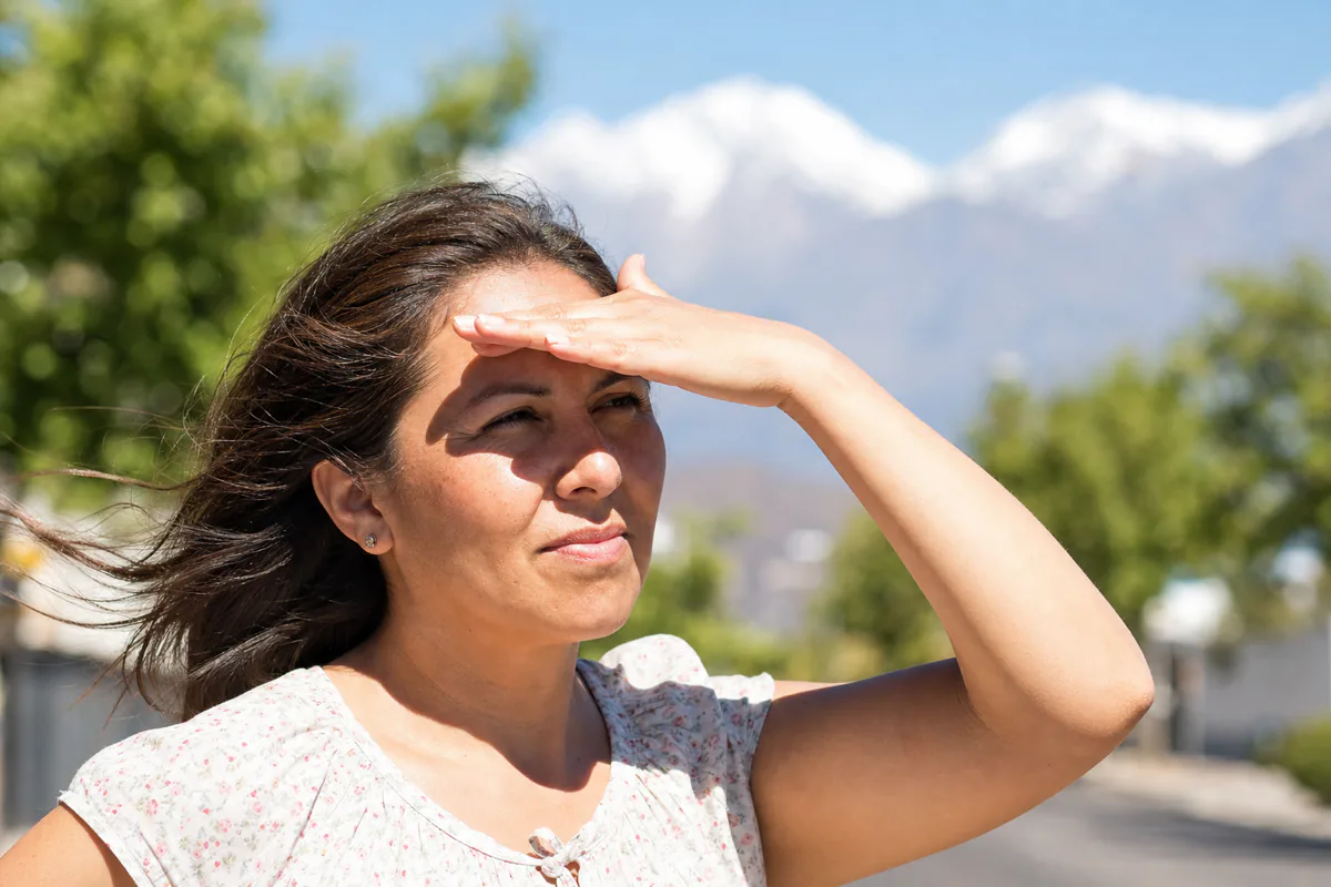 Mujer chilena protegiéndose del sol en Santiago, principal causa de manchas en la cara por radiación ultravioleta